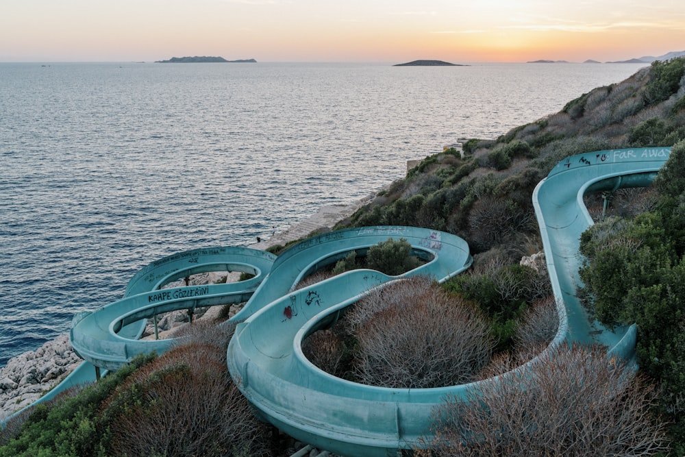 a water slide on the side of a cliff next to the ocean