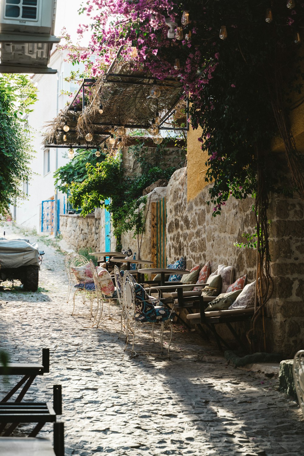 a cobblestone street lined with tables and chairs