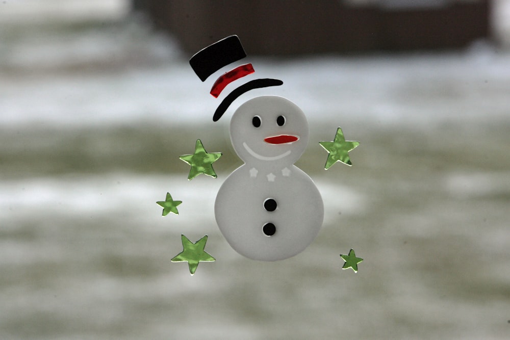 a snowman with a top hat and green stars