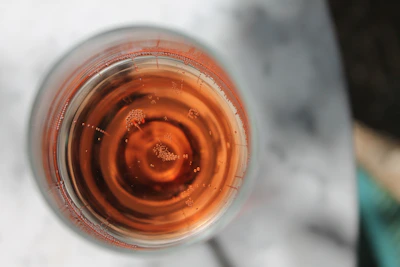 Close-up of a glass filled with clear, sparkling alkaline water on a wooden table.