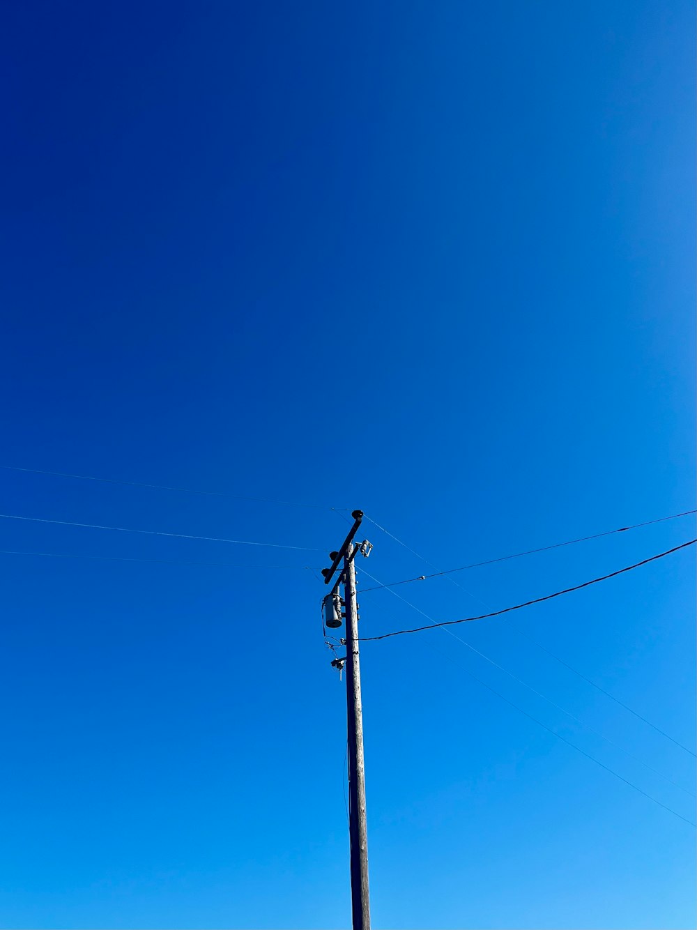 a telephone pole with a blue sky in the background