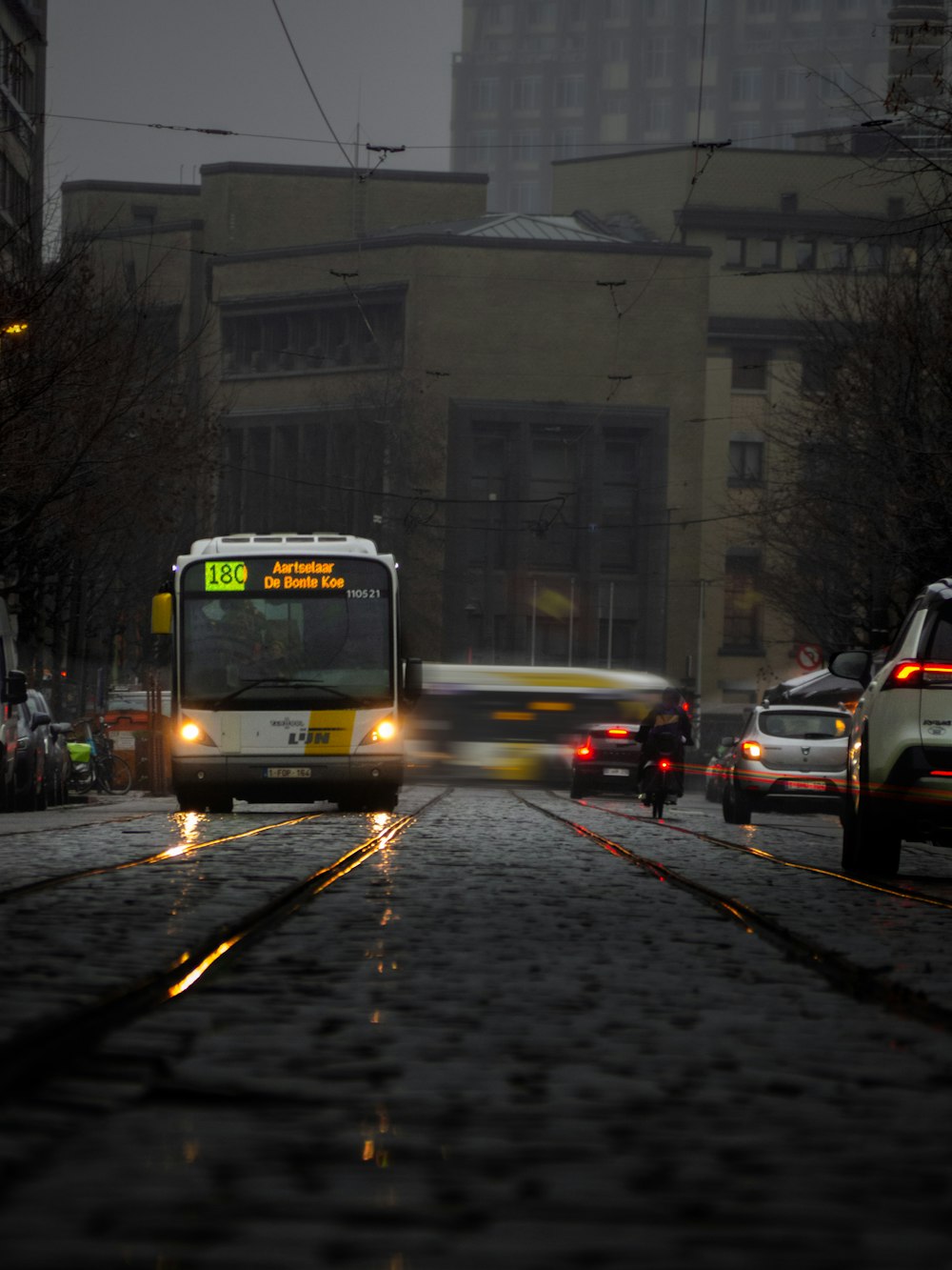 a city street at night with cars and buses