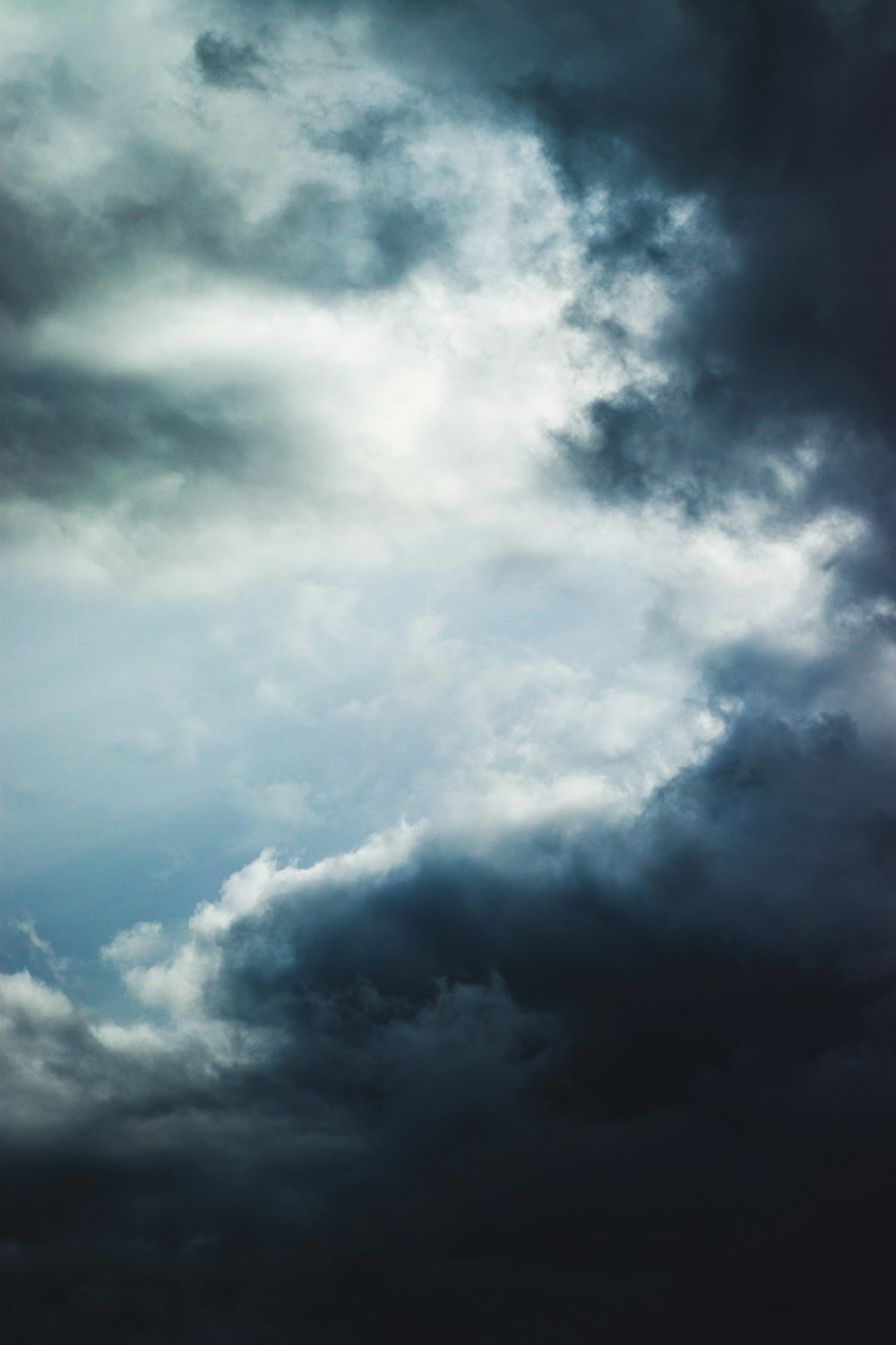 a plane flying through a cloudy sky on a cloudy day