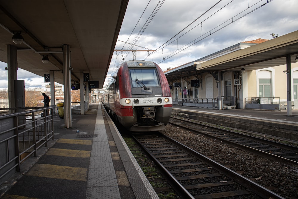 a red and white train pulling into a train station