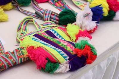 Colorful handmade tote bags displayed on a rustic wooden table