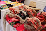 Colorful murga masks and instruments laid out on a wooden table with carnival decorations.