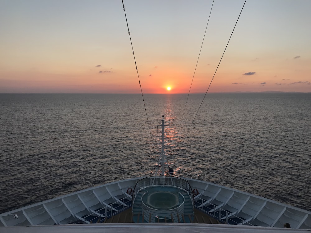 the sun is setting over the ocean on a cruise ship