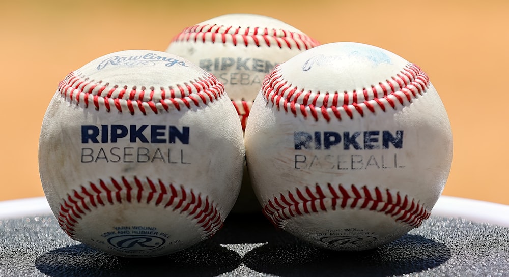 Tres pelotas de béisbol sentadas encima de una mesa