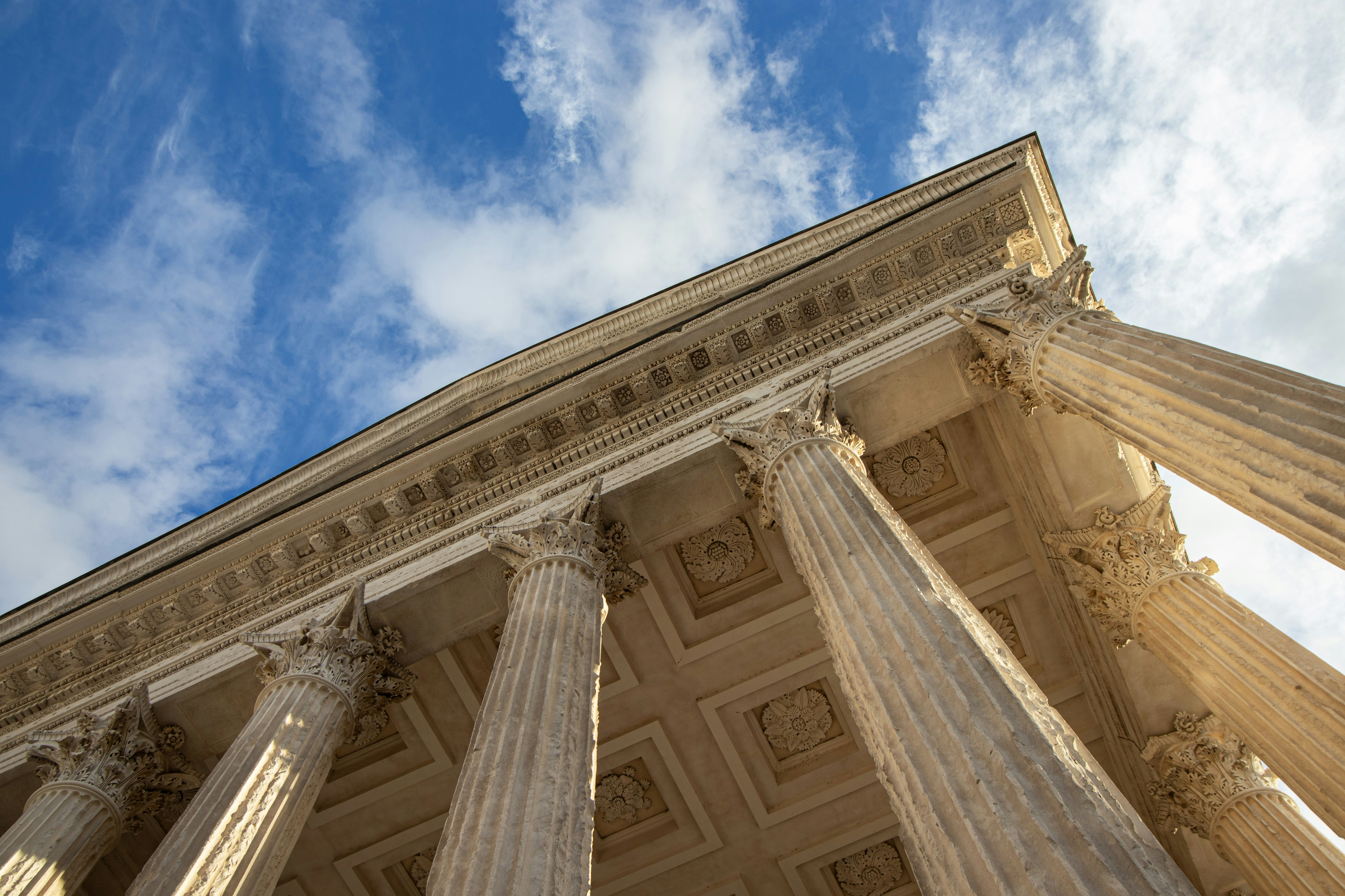 the columns of a building against a blue sky, Fronton de la Maison Carrée de Nîmes, France (2k23)