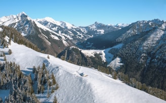 Snow-covered peaks of the Himalayas with a cozy cabin in the foreground.