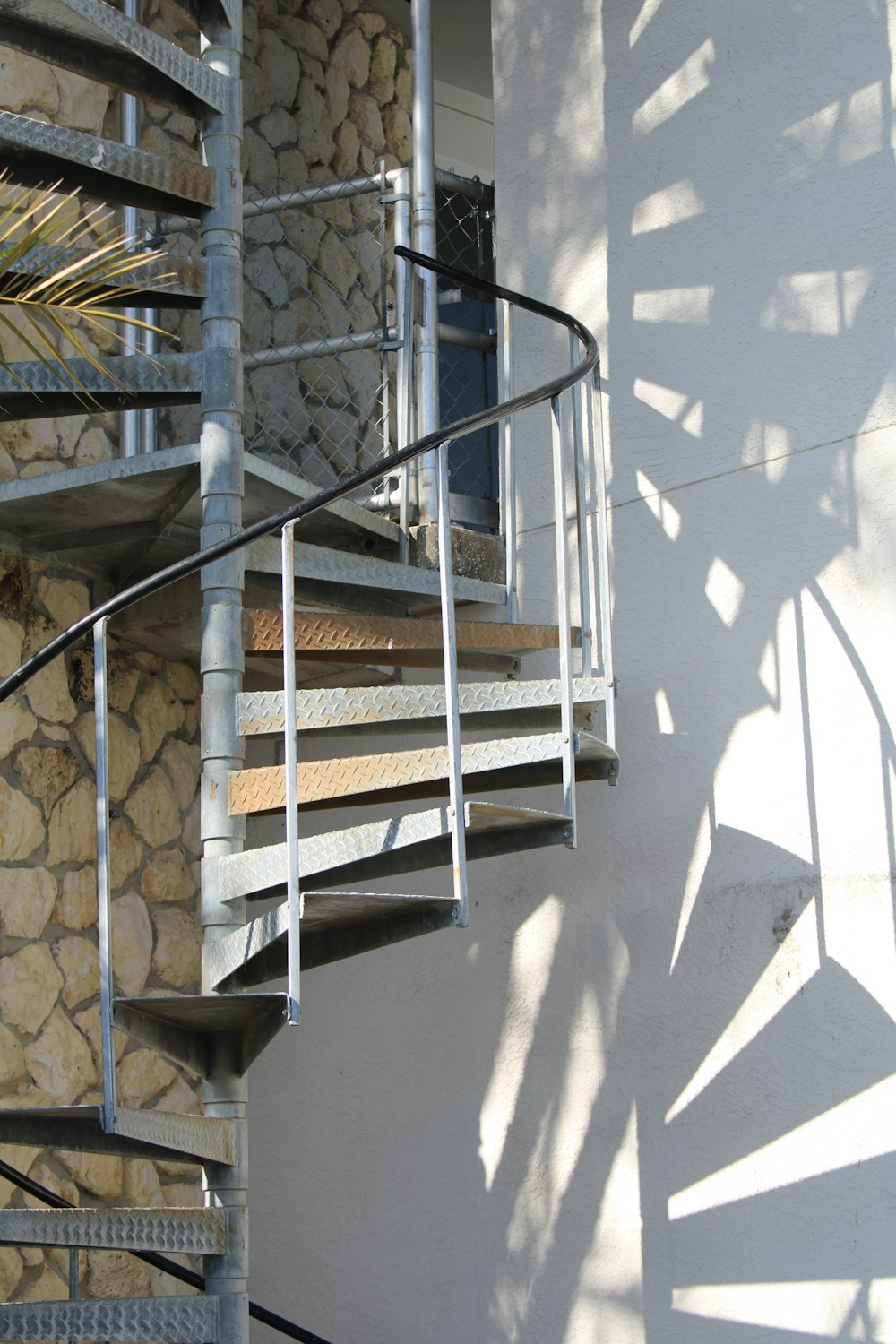 a spiral staircase next to a stone wall