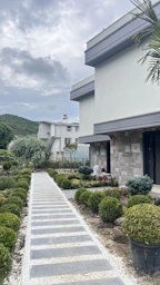 A completed modern house with a welcoming front porch and garden.