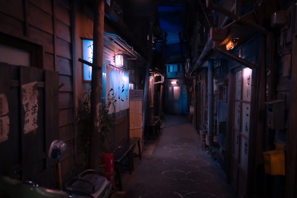 a narrow alley with a bench and a car parked on the side of the road