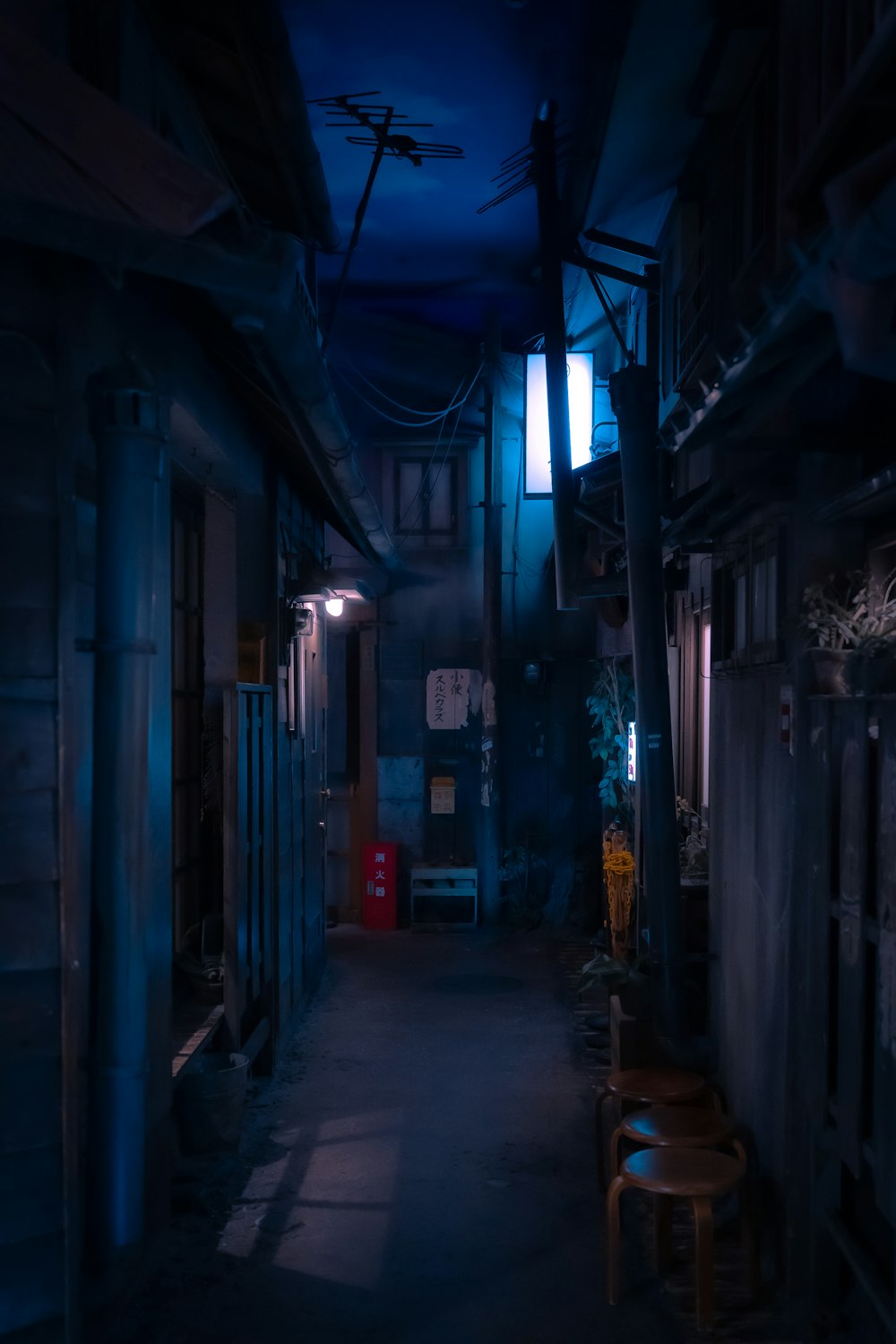 a dark alley with a chair and a table