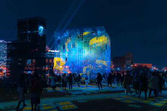 a group of people standing around a building at night
