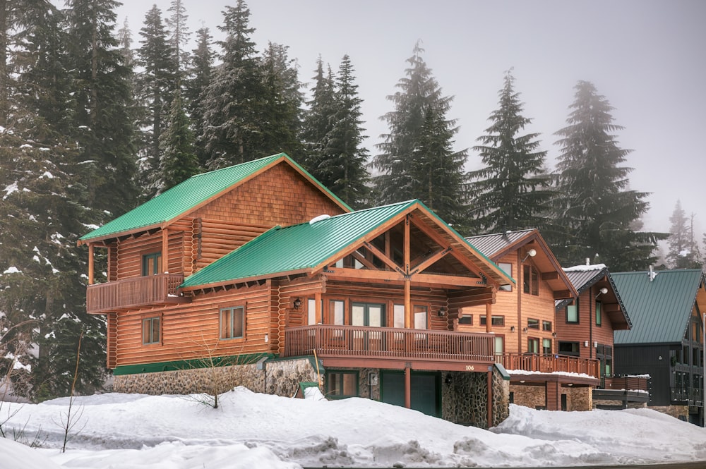 a large log cabin with a green roof