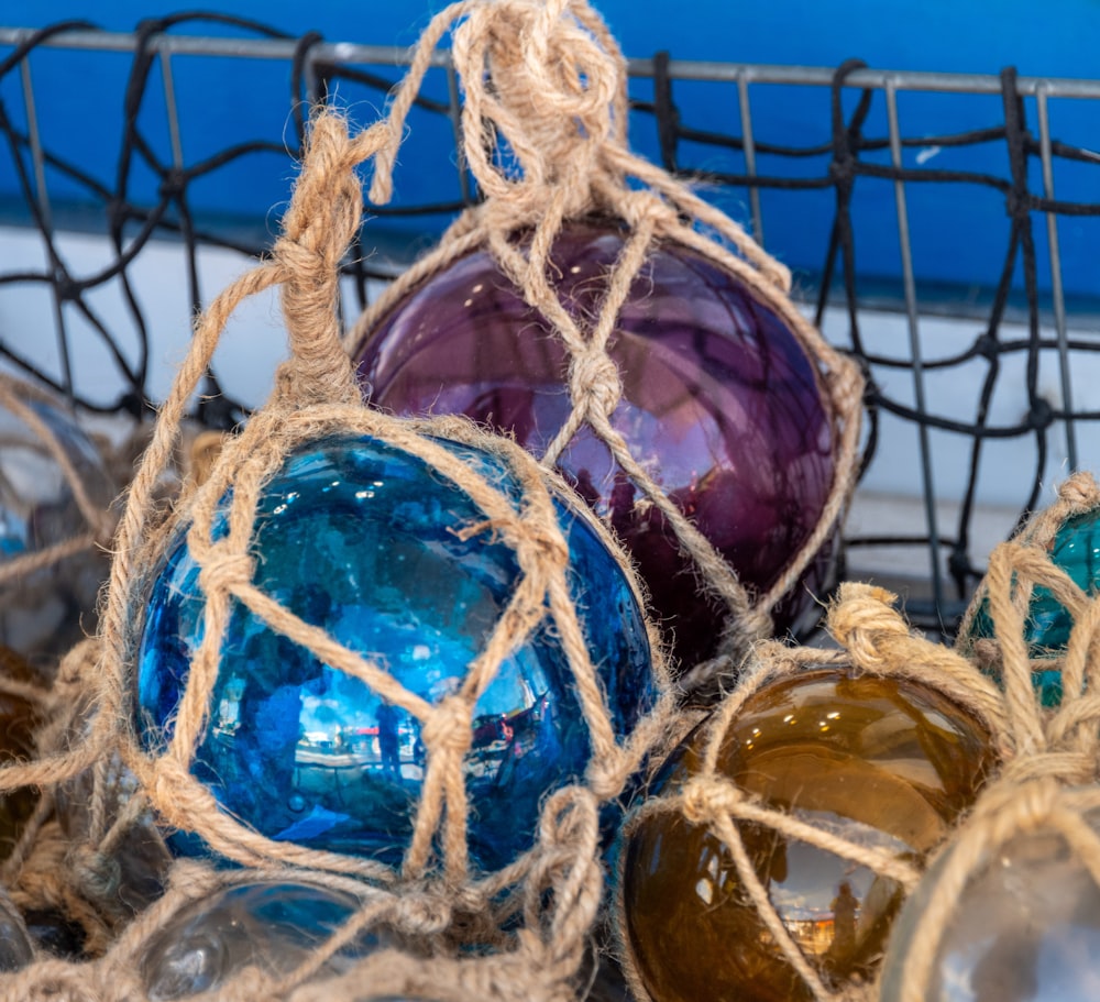 a basket filled with different colored glass ornaments