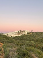 A panoramic view of a sprawling modern building complex with lush greenery.