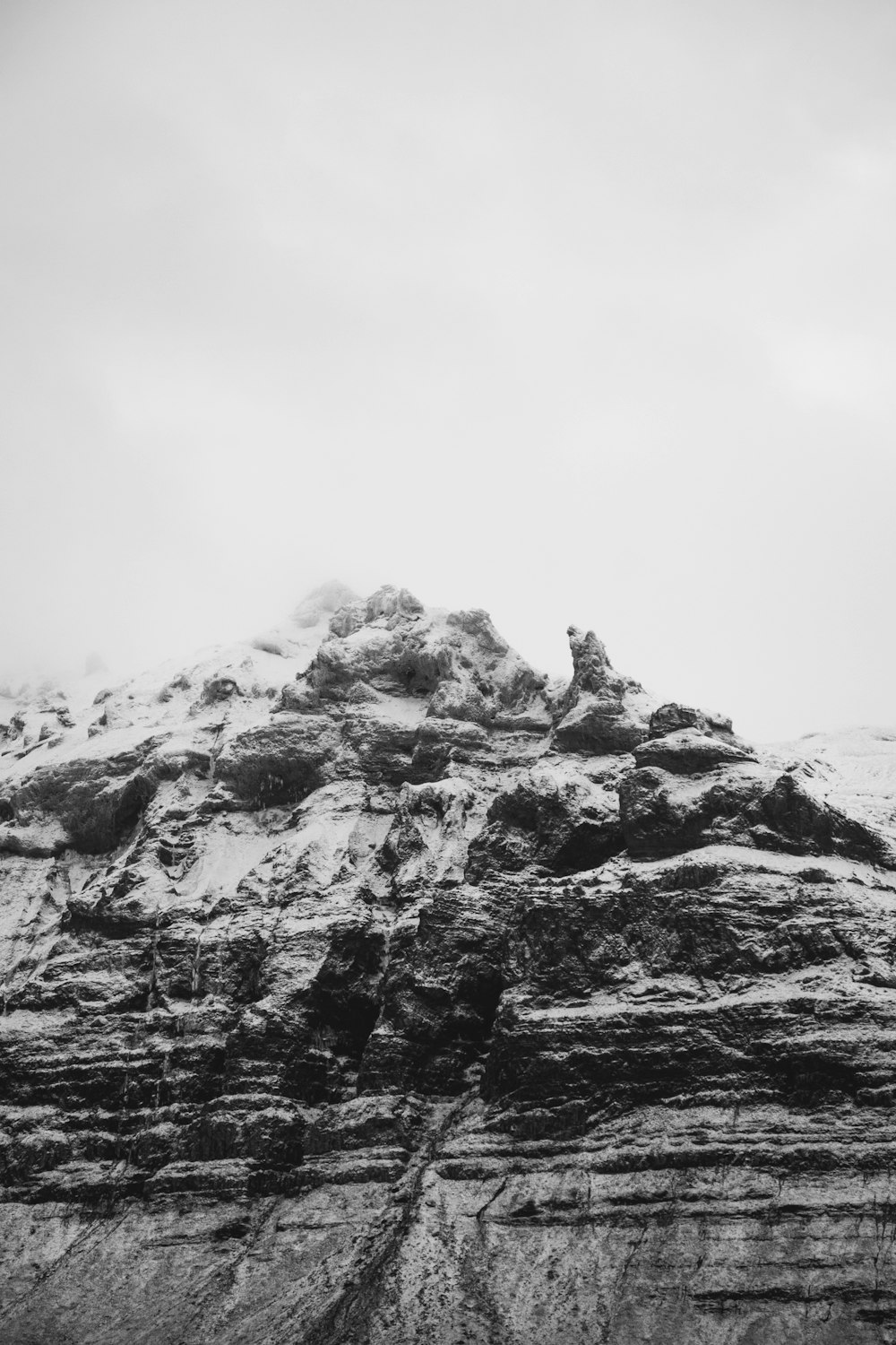 a black and white photo of a snowy mountain