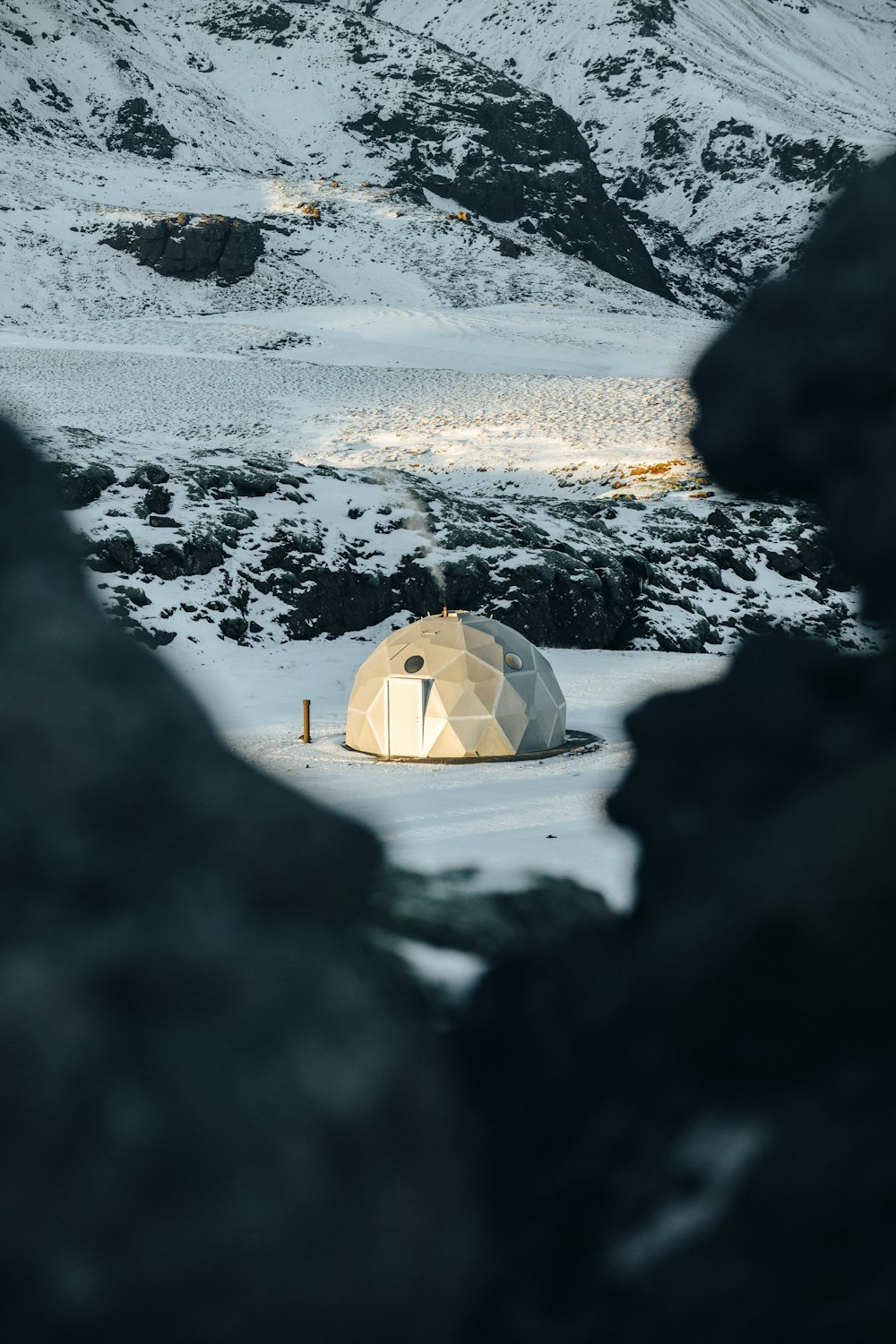 an igloose in the middle of a snowy field