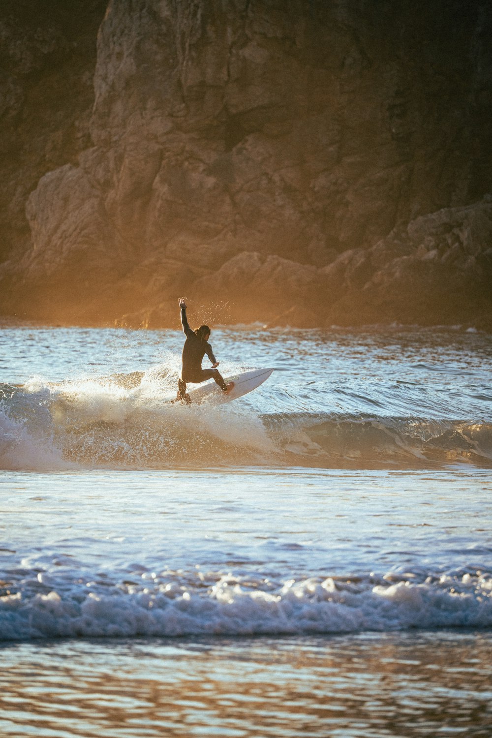 a man riding a wave on top of a surfboard