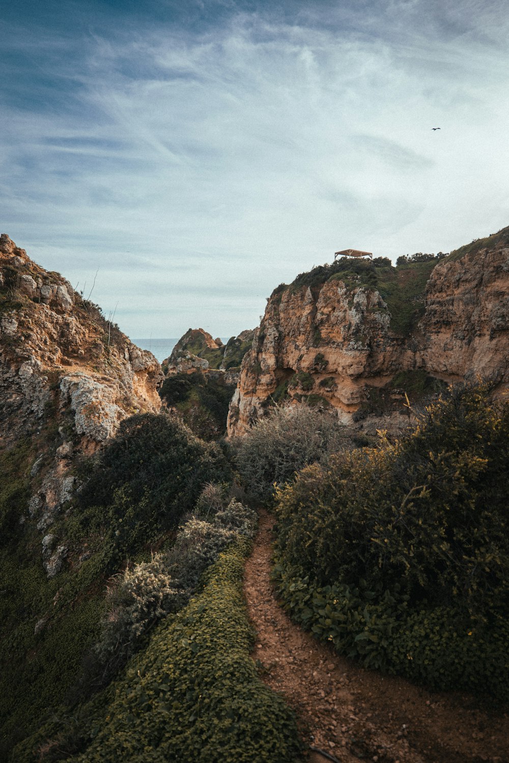 a dirt path leading to a rocky cliff