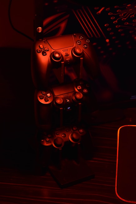 Stack of popular video game cases next to a glowing gaming headset
