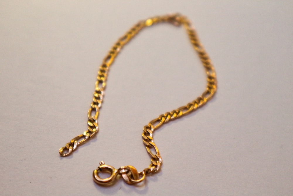 a gold chain with a letter on it