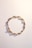a close up of a bracelet on a white surface