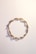 a close up of a bracelet on a white surface