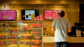 Friendly staff serving customers at a bustling Dunkin' Donuts counter.