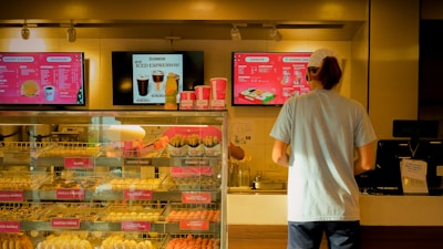 Friendly staff serving customers at a bustling Dunkin' Donuts counter.