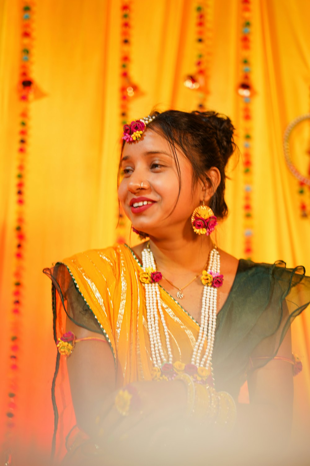 Uma mulher em um sari amarelo sorri para a câmera