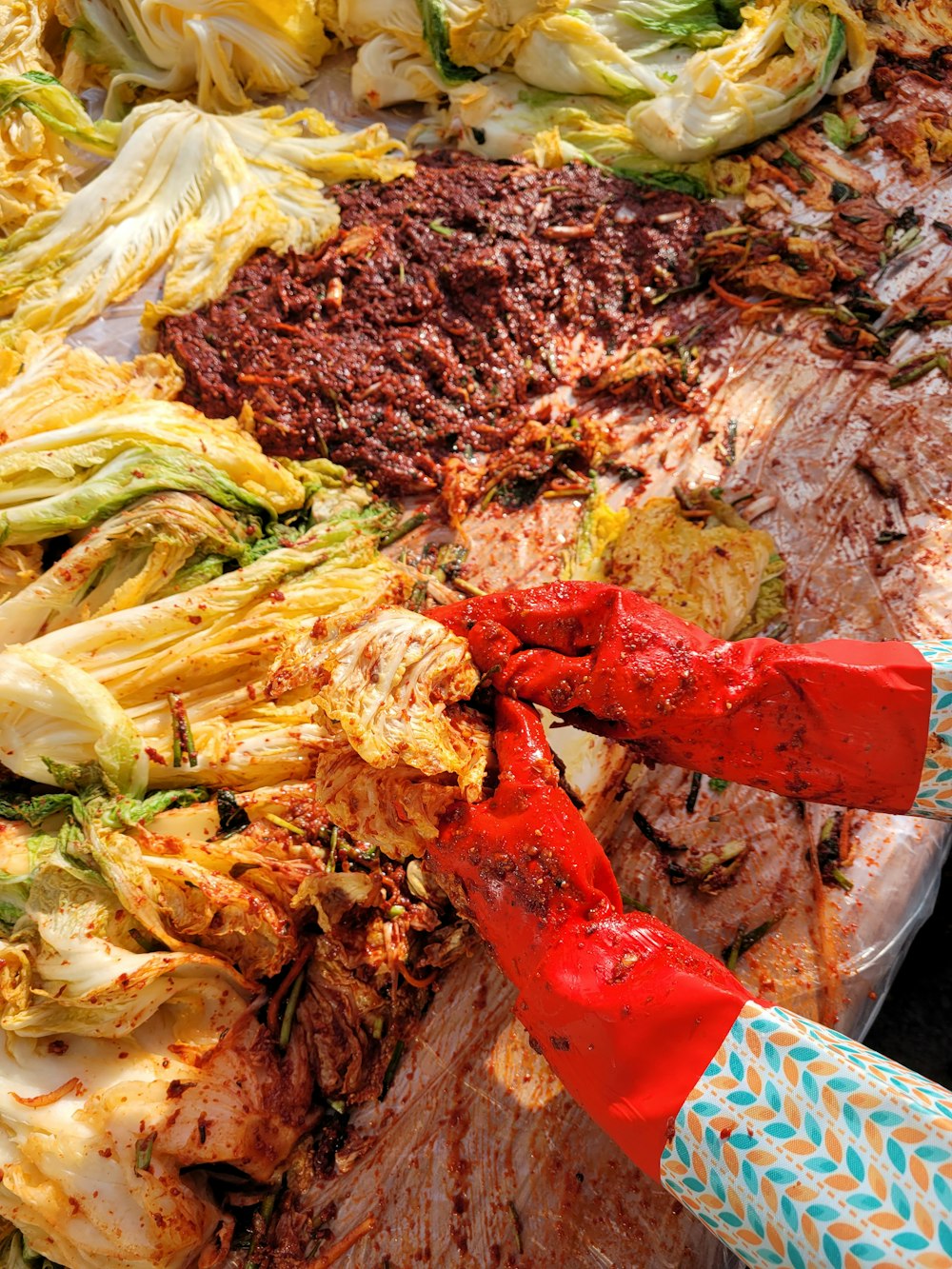 a person holding a knife over a large pile of food