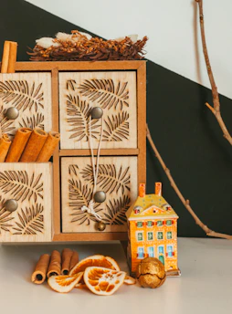 Close-up of a beautifully glazed ceramic ornament beside a rustic spice storage box on a wooden shelf