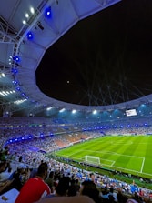 An electrifying sports stadium filled with cheering fans under bright lights.