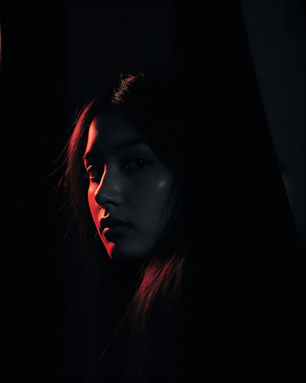 a woman with long hair standing in the dark