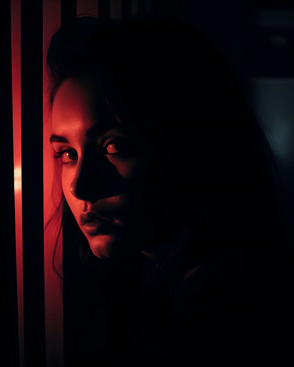a woman looking out of a window in the dark