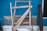 A sturdy aluminum ladder leaning against a wall in a workshop.