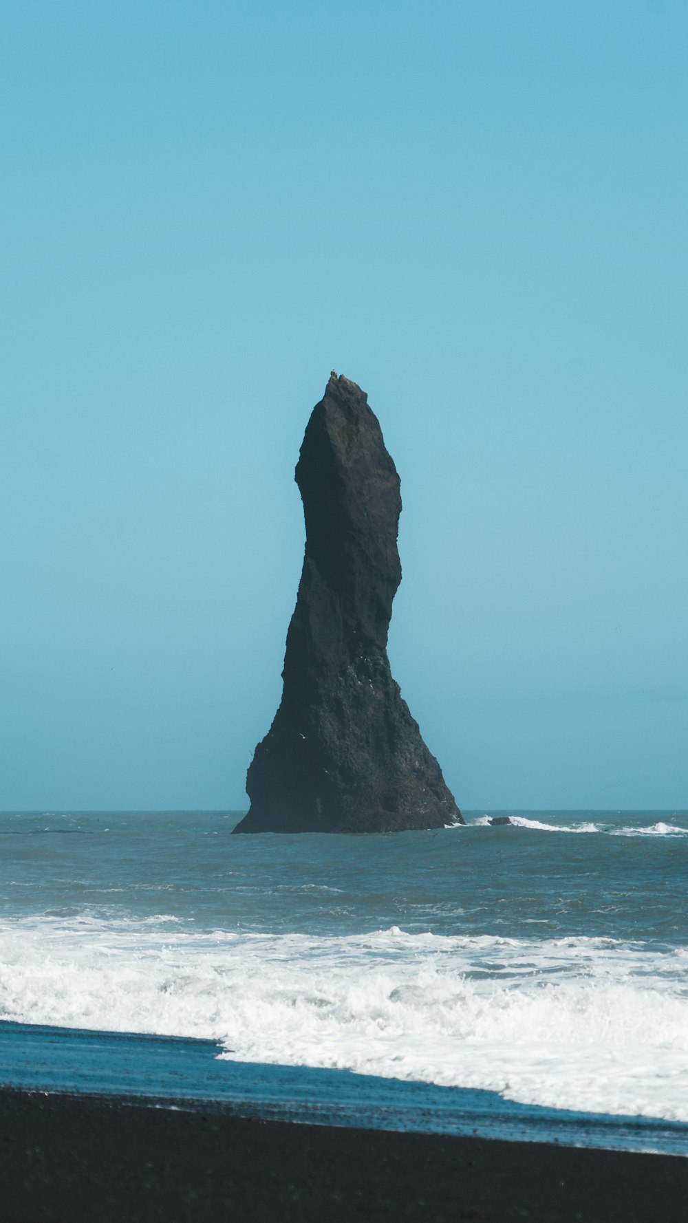 a large rock sticking out of the ocean