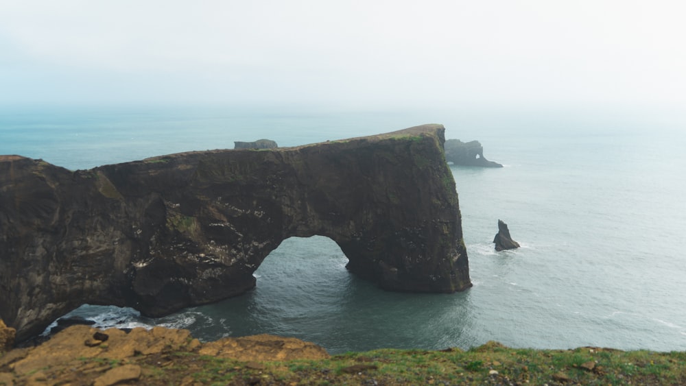 a large rock formation in the middle of a body of water