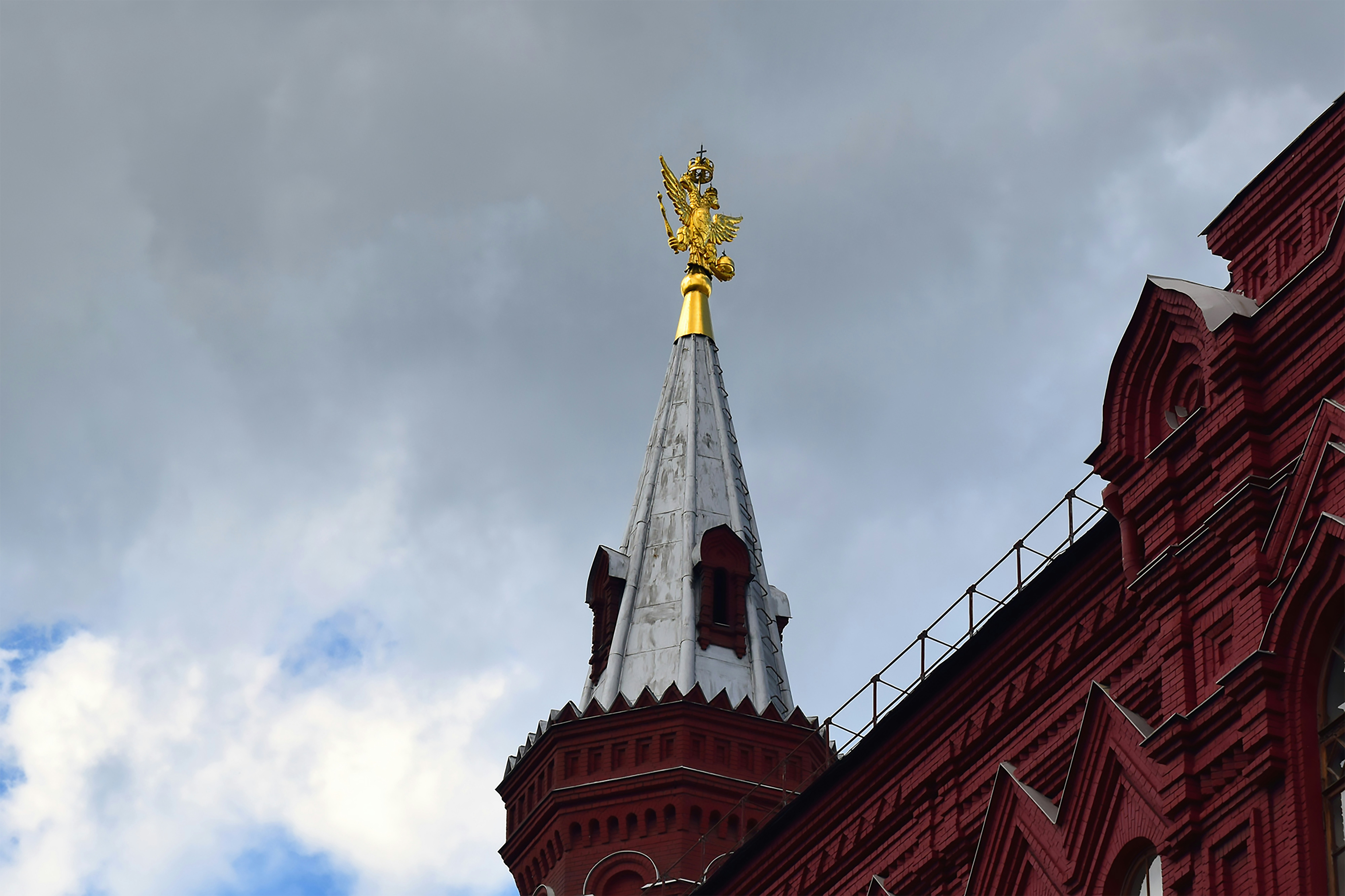 a tall building with a gold statue on top of it