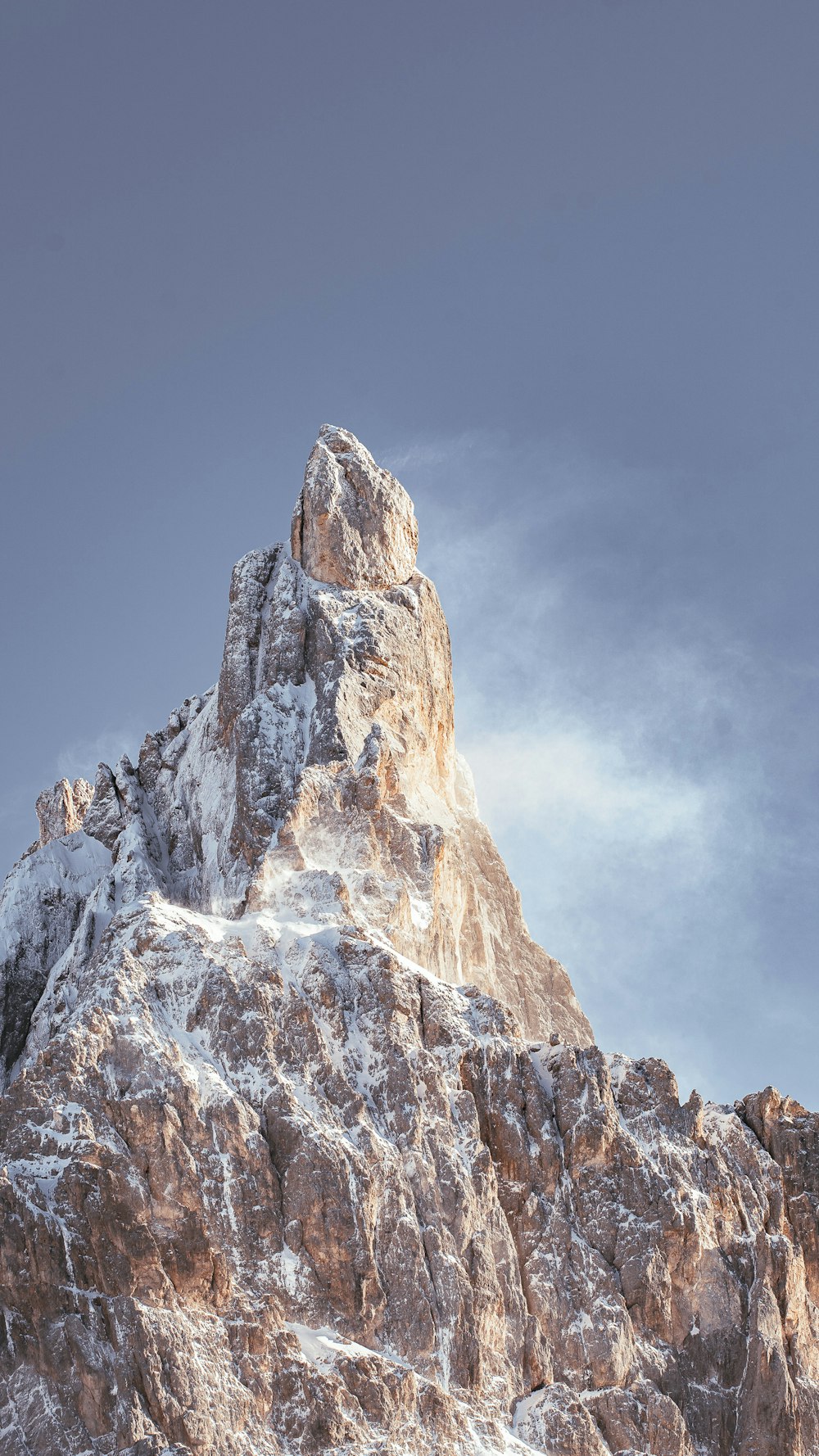 a very tall mountain covered in snow under a blue sky