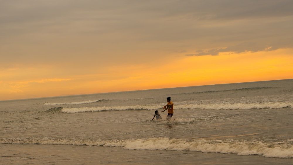 a man and a child are playing in the ocean
