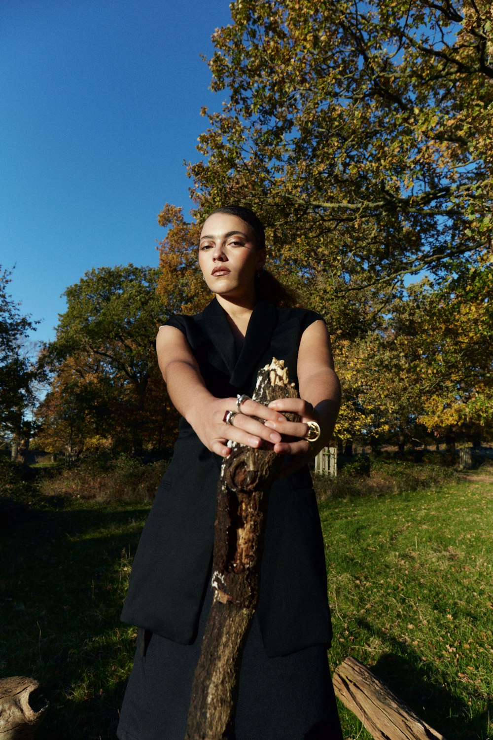 a woman in a black dress holding a snake