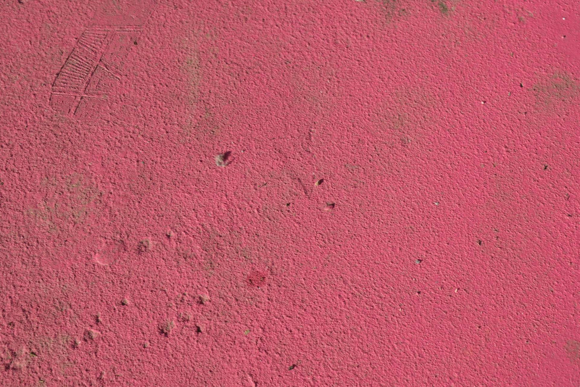 a close up of a pink wall with small holes in it