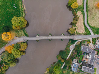 A completed solar-powered water point next to a modular bridge in a green countryside.