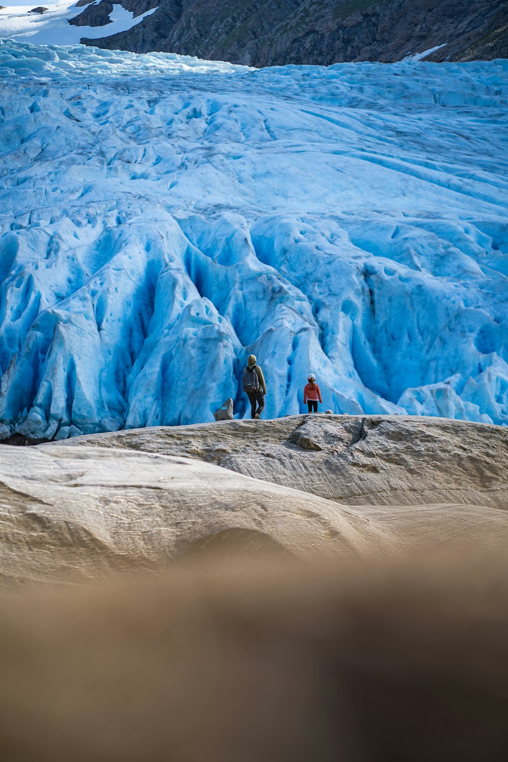 a group of people standing on top of a glacier