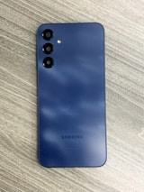 a blue samsung phone sitting on top of a wooden table