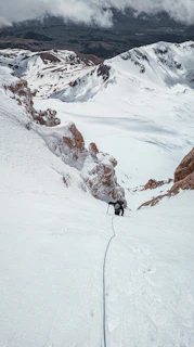 A lone climber silhouetted against a towering icy summit.